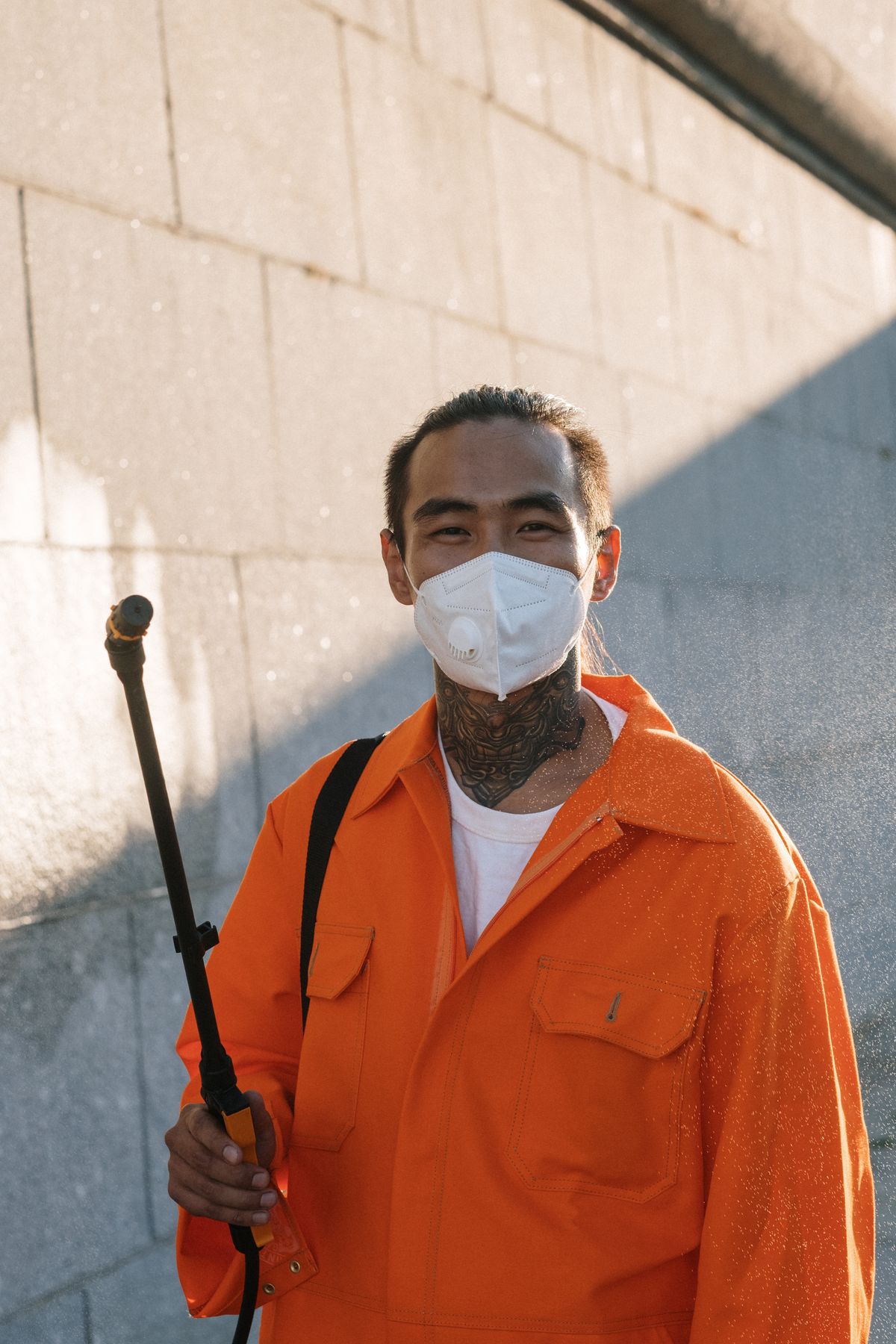 EcoGuard technician with sprayer and face mask